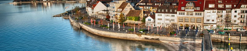 Uferpromenade mit bunten Häusern an einem ruhigen See