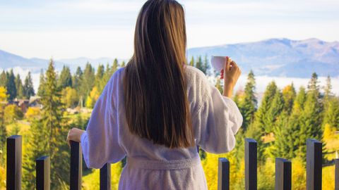 Frau im Bademantel mit Blick auf die Berge