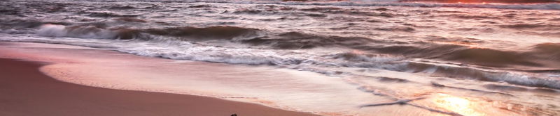Auslaufende Wellen an einem Ostseestrand im Abendrot