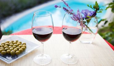 Genehmige dir ein Glas Wein am Pool deines Hotels