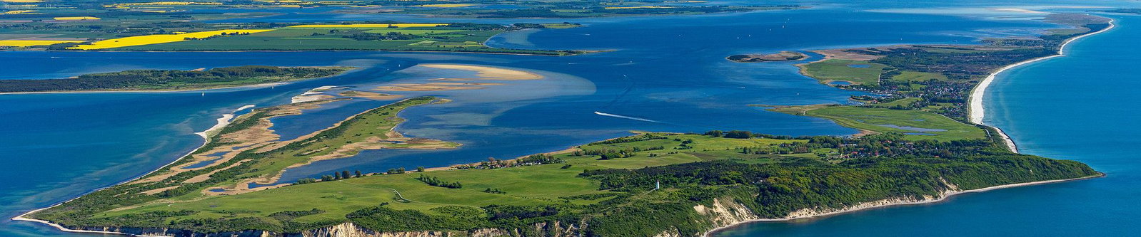Luftaufnahme einer grünen Halbinsel mit Sandbänken und Steilküste in der Ostsee