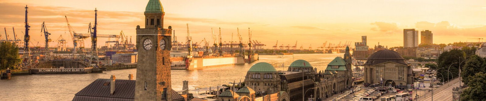 Landungsbrücken und Hafenkräne an der Elbe im Sonnenuntergang