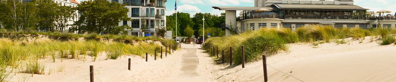 Sandweg durch die Dünen zum Strand vor einem Strandhotel
