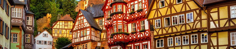 Bunte Fachwerkhäuser reihen sich an einem Hang in einer fränkischen Altstadt