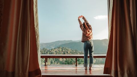 Frau auf dem Balkon im Hotelzimmer 