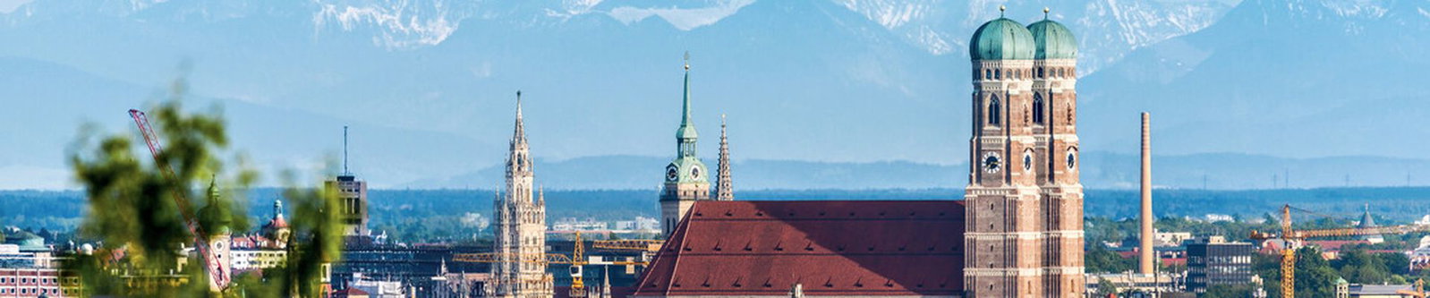 Zwiebeltürme der Frauenkirche über der Münchner Altstadt vor der Alpenkette