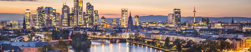 Hochhaus-Skyline und Brücken über einem Fluss in der Abenddämmerung