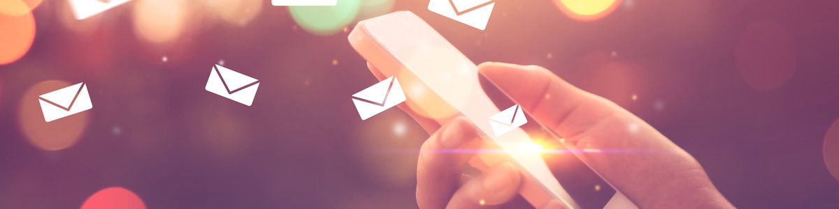 Eine Hand hält ein Smartphone, aus dem mehrere schwebende Briefumschlag-Symbole hervorgehen, als Sinnbild für digitale Nachrichten, E-Mails oder mobile Kommunikation.